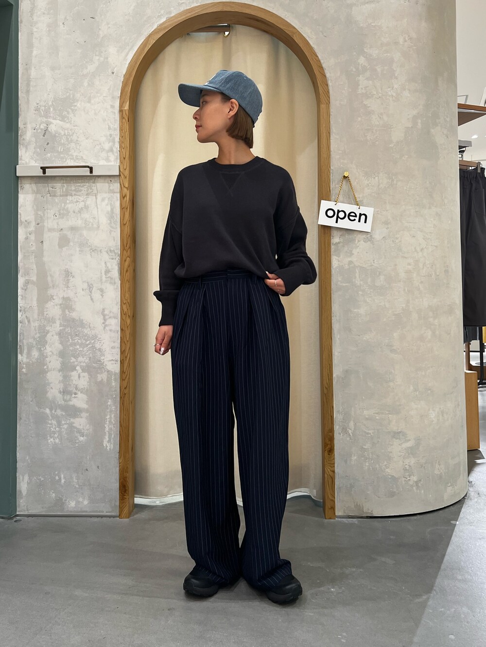 ブルー系のスラックス、グレー系のニット/セーターを着用したレディースの秋コーディネートの2枚目の写真