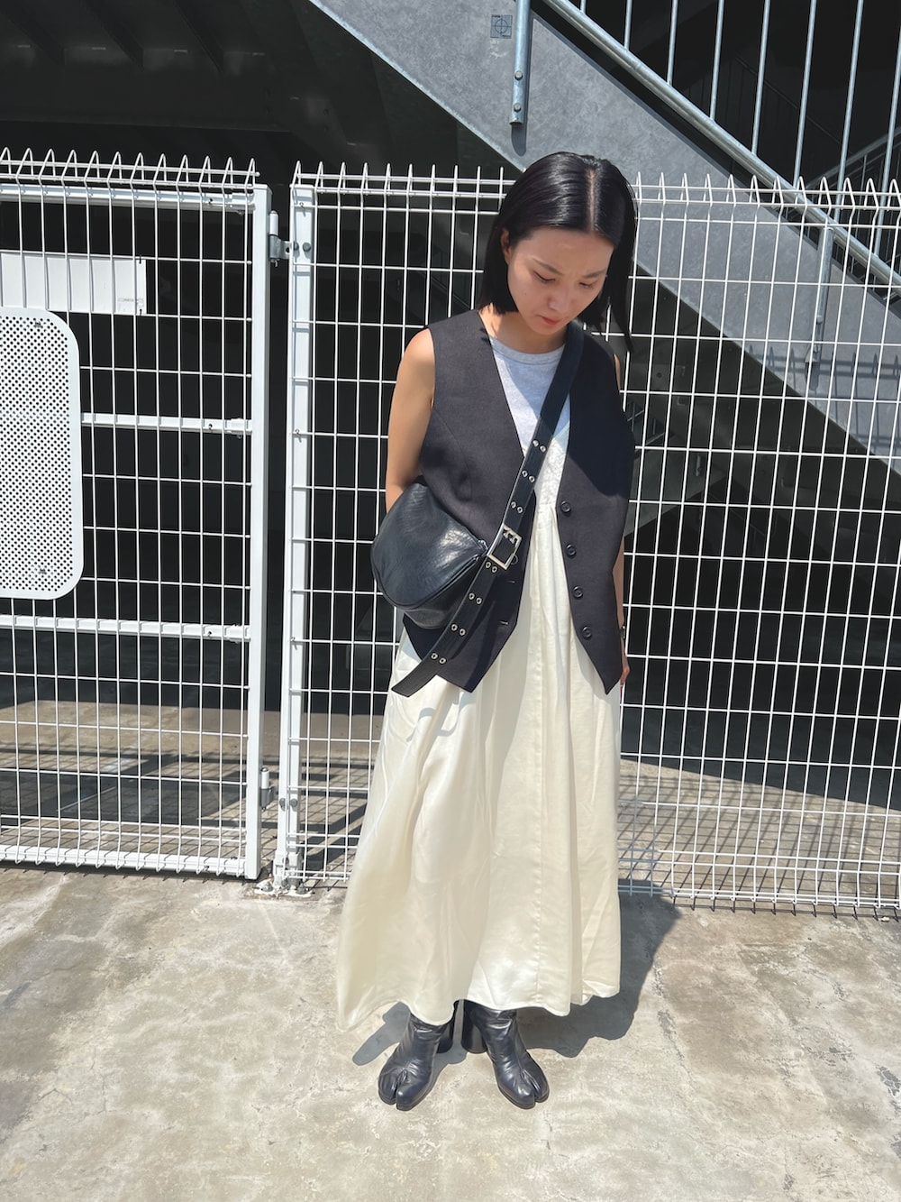 ホワイト系のワンピース、ブラック系のショルダーバッグを着用したレディースの秋コーディネートの3枚目の写真