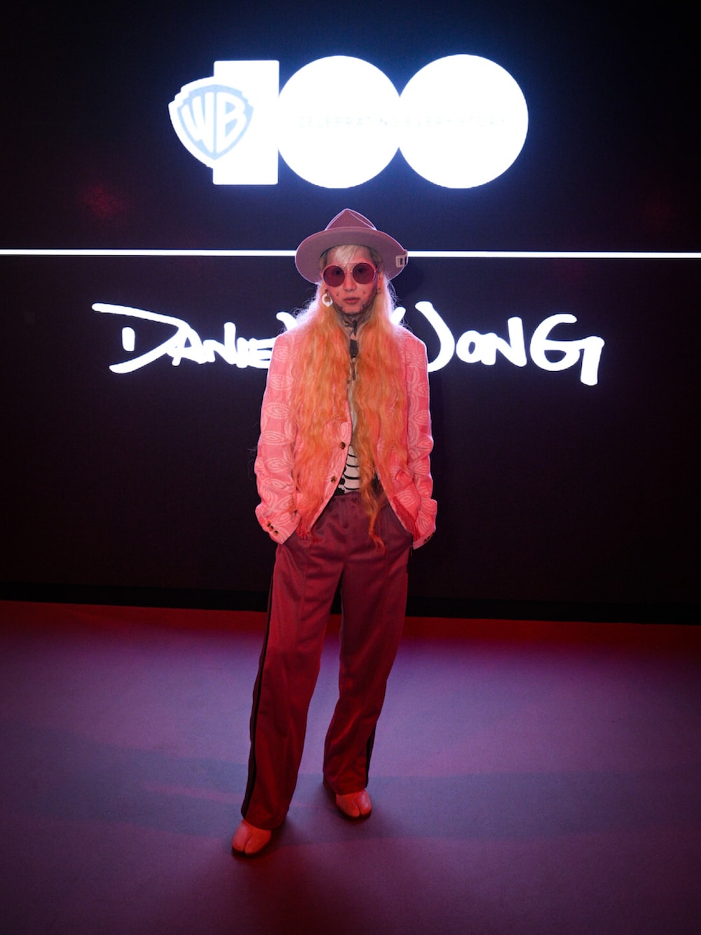 ピンク系のテーラードジャケット、ピンク系のチノパンツ、ホワイト系のパンプスを着用したメンズの夏コーディネートの4枚目の写真