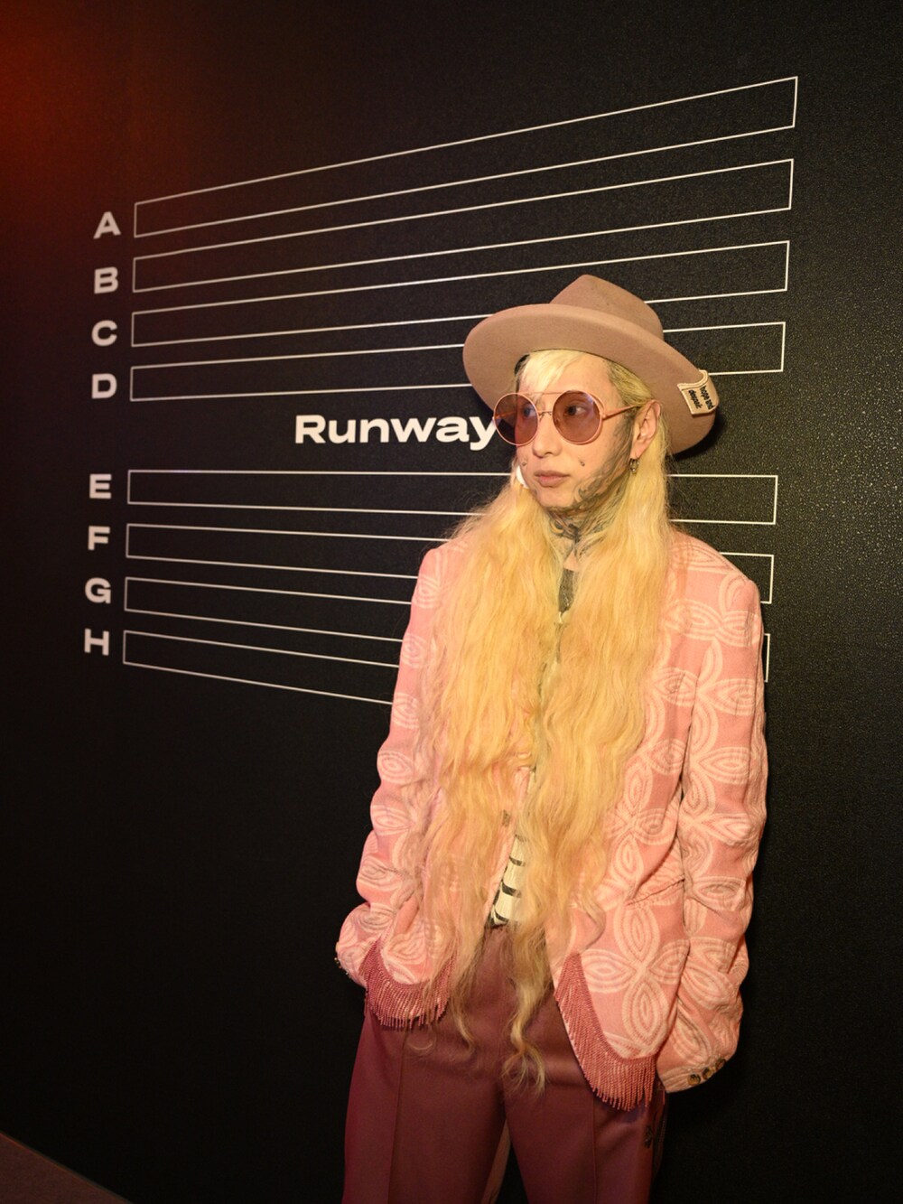 ピンク系のテーラードジャケット、ピンク系のチノパンツ、ホワイト系のパンプスを着用したメンズの夏コーディネートの3枚目の写真