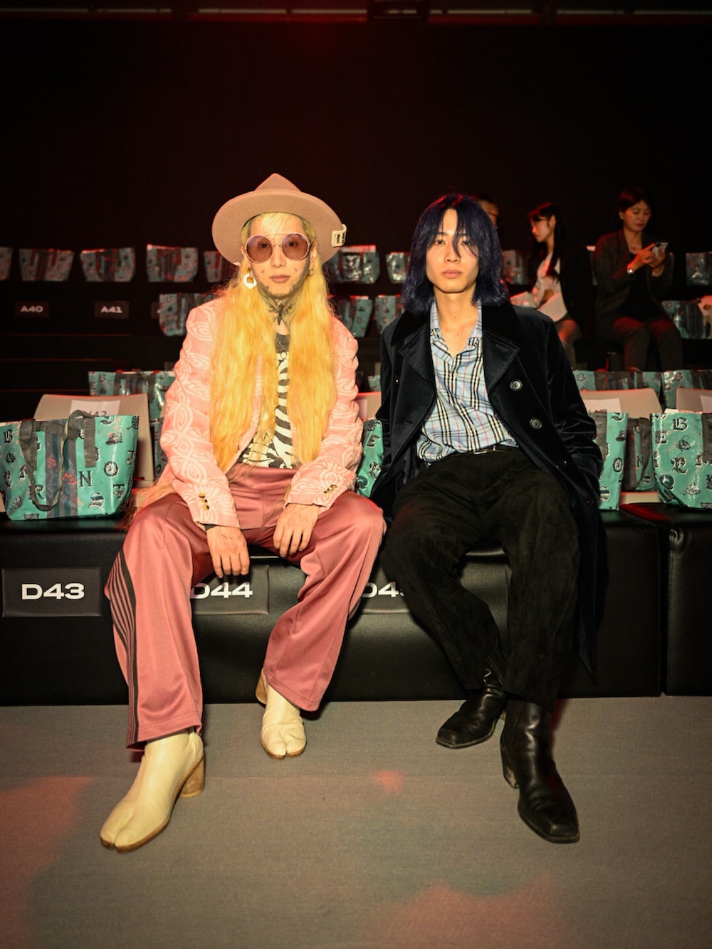 ピンク系のテーラードジャケット、ピンク系のチノパンツ、ホワイト系のパンプスを着用したメンズの夏コーディネートの2枚目の写真