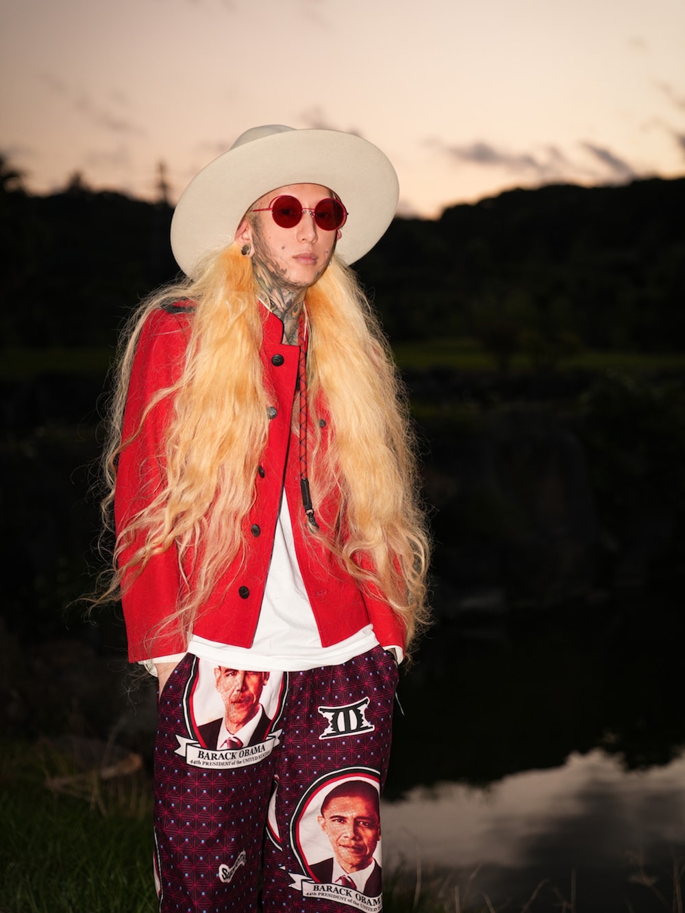 レッド系のミリタリージャケット、レッド系のチノパンツ、ホワイト系のスニーカーを着用したメンズの春コーディネートの2枚目の写真