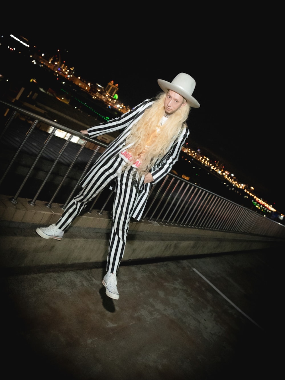 ホワイト系のTシャツ/カットソー、ホワイト系のチェスターコート、ホワイト系のスラックスを着用したメンズの春コーディネートの2枚目の写真