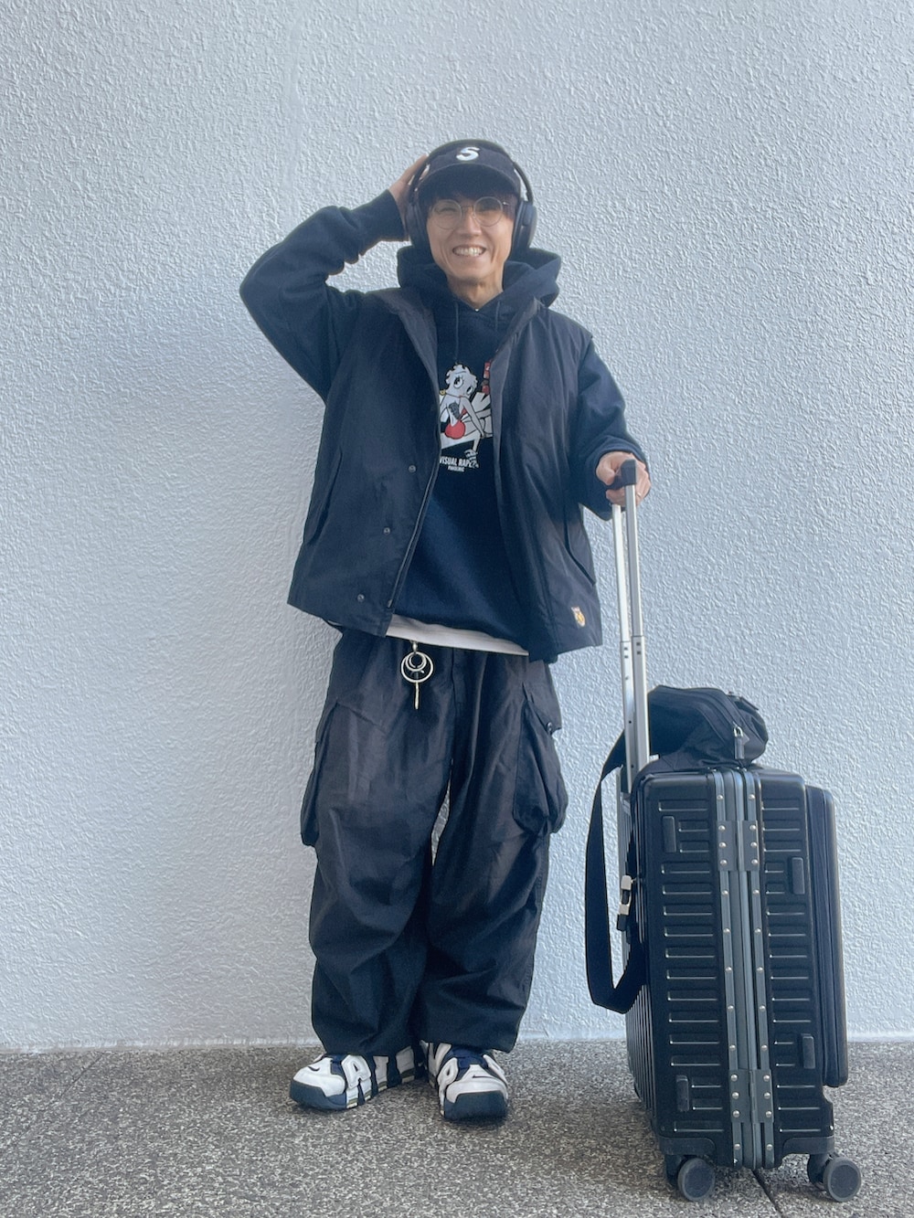 ホワイト系のスニーカー、ブラック系のカーゴパンツ、ブラック系のパーカーを着用したメンズの冬コーディネートの2枚目の写真