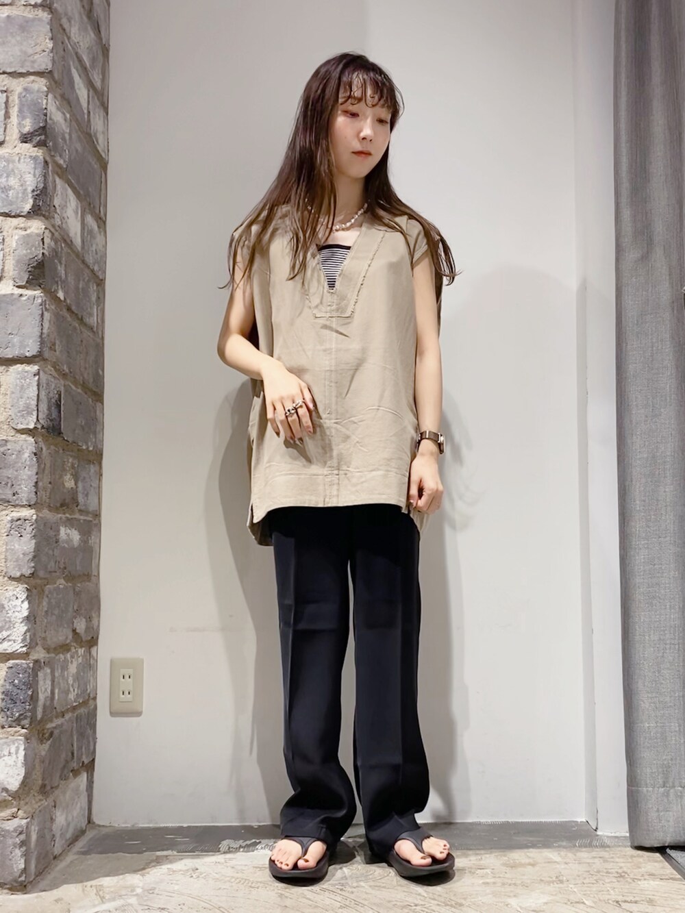 ベージュ系のベスト、ブラック系のスラックス、その他のタンクトップを着用したレディースの夏コーディネートの2枚目の写真