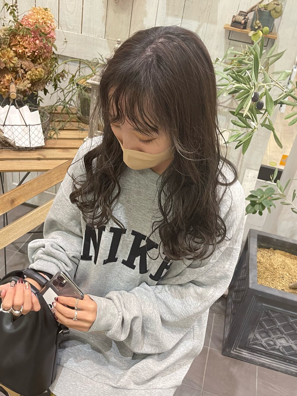 ブラック系のハンドバッグ、グリーン系のその他パンツを着用したレディースの冬コーディネートの2枚目の写真