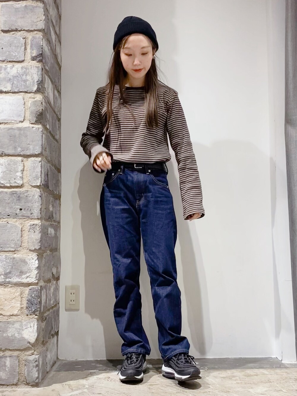 ブラウン系のTシャツ/カットソー、ブルー系のデニムパンツを着用したレディースの冬コーディネートの2枚目の写真