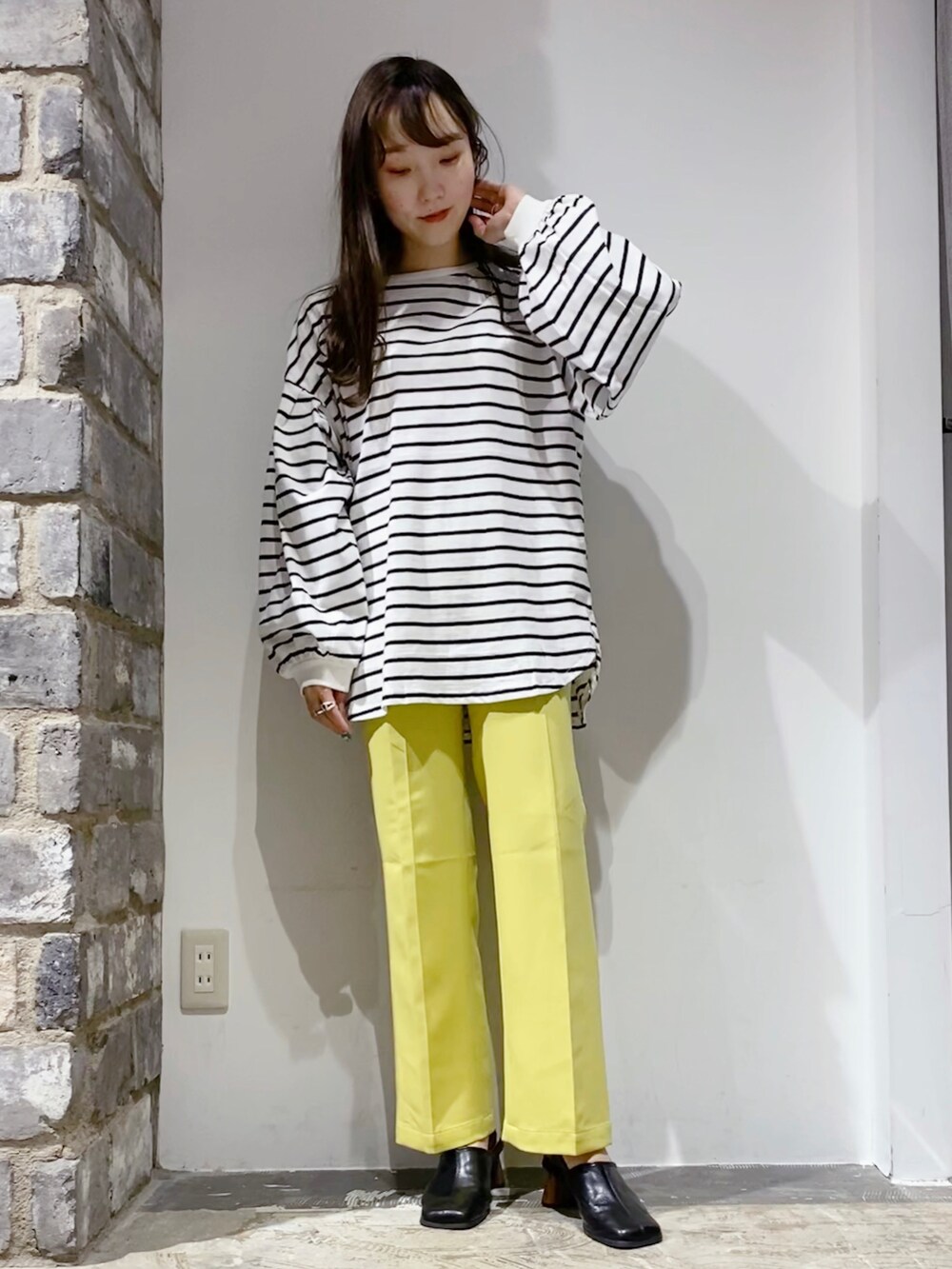 イエロー系のその他パンツ、ブラック系のサンダルを着用したレディースの冬コーディネートの2枚目の写真