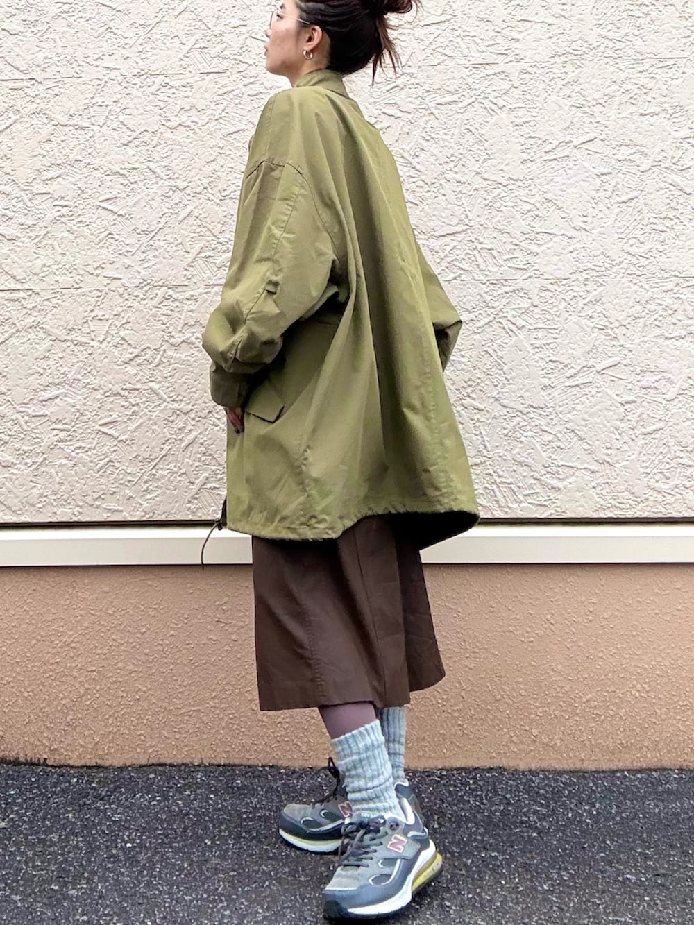 ピンク系のTシャツ/カットソー、ホワイト系のニット/セーター、グリーン系のモッズコートを着用したレディースの冬コーディネートの2枚目の写真