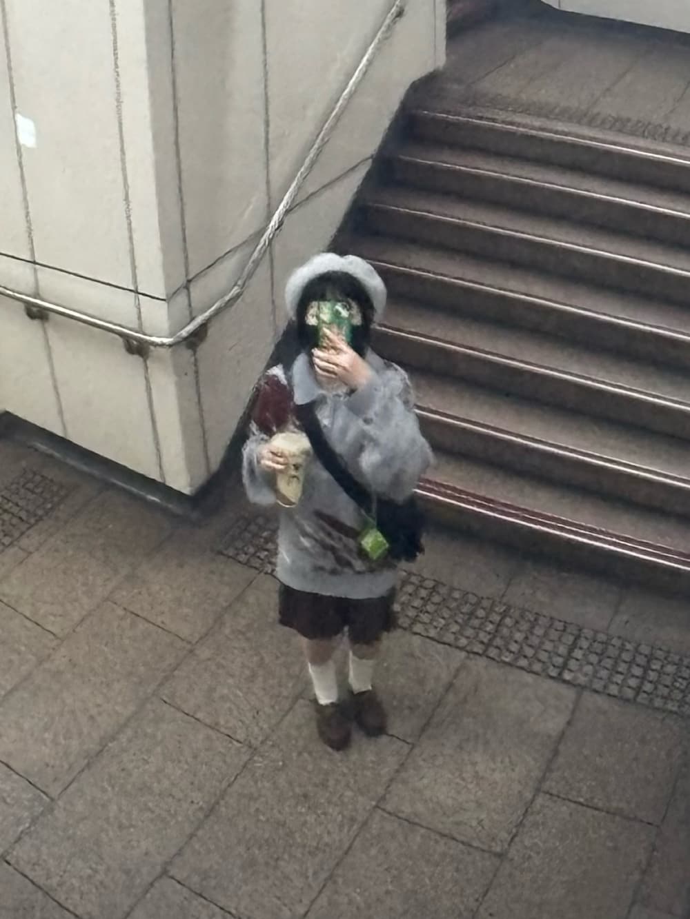 グレー系のポロシャツ、ブラウン系のローファー、ブラウン系のワンピースを着用したレディースの冬コーディネートの2枚目の写真