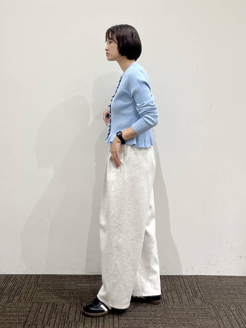 グレー系のスウェットパンツ、ブラック系のショルダーバッグ、ブルー系のTシャツ/カットソーを着用したレディースの冬コーディネートの3枚目の写真