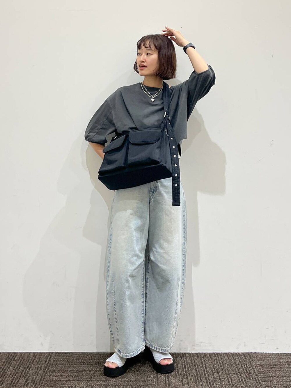 シルバー系のサンダル、ブラック系のショルダーバッグ、ブルー系のデニムパンツを着用したレディースの夏コーディネートの4枚目の写真