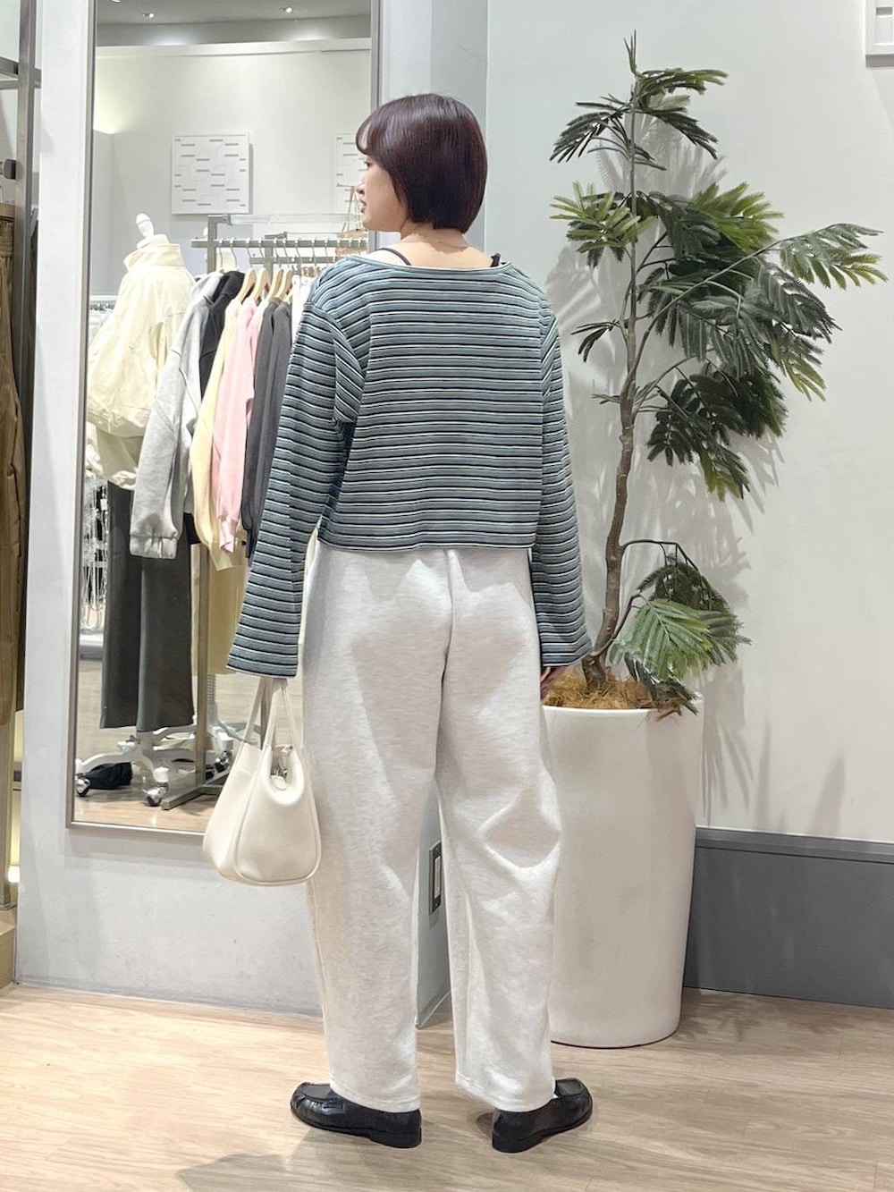 ブラック系のTシャツ/カットソー、グレー系のスウェットパンツ、ホワイト系のショルダーバッグを着用したレディースの春コーディネートの4枚目の写真