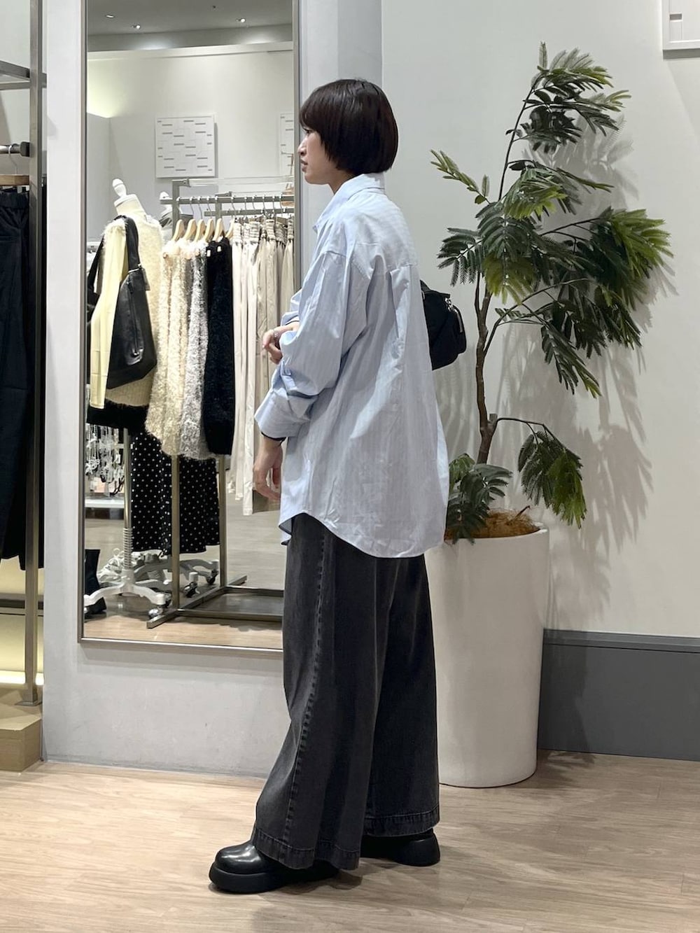 ブラック系のデニムパンツ、ブラック系のボストンバッグ、ブラック系のサンダルを着用したレディースの冬コーディネートの3枚目の写真