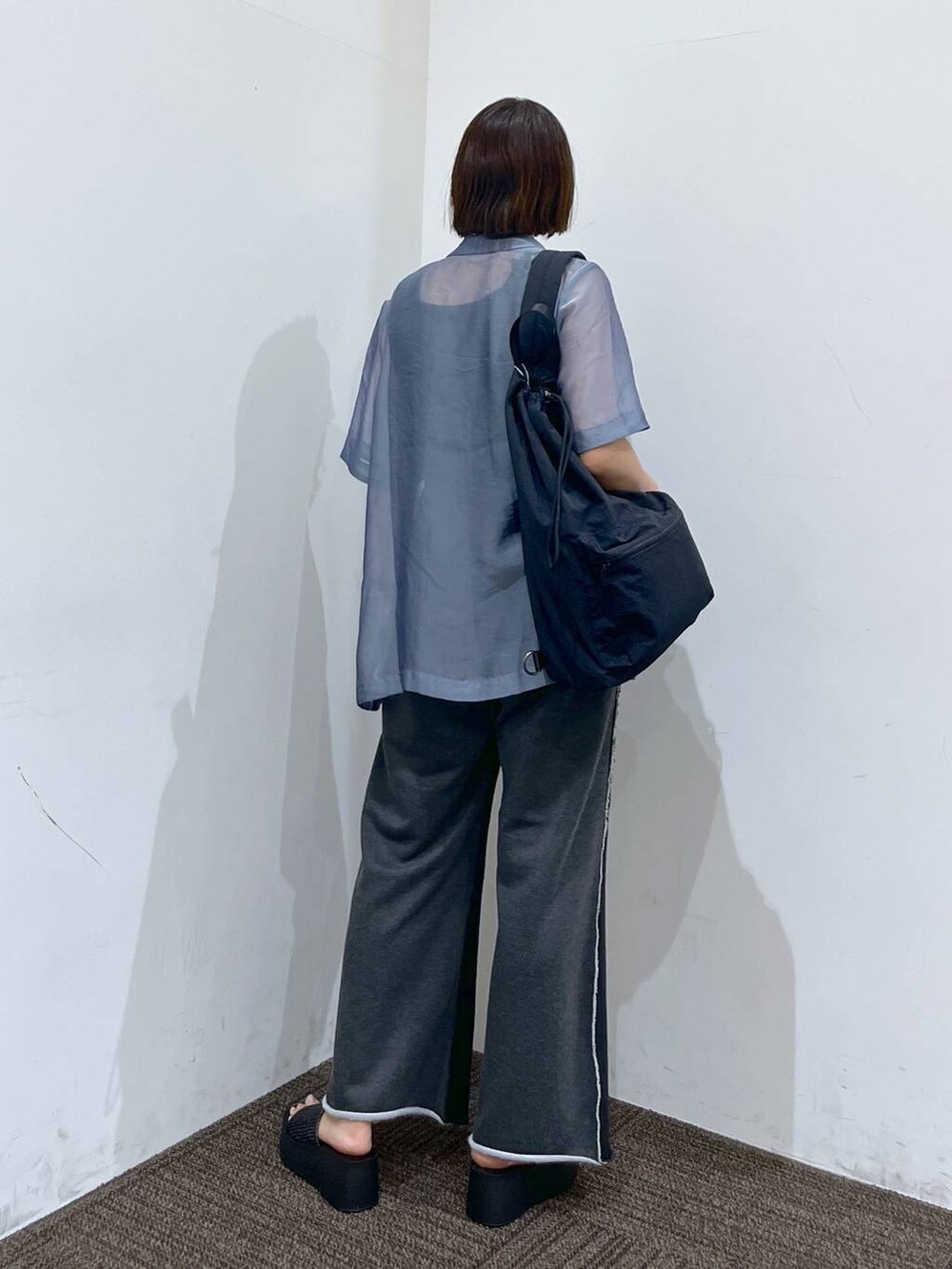 ブラック系のサンダル、ブラック系のショルダーバッグ、ブラック系のタンクトップを着用したレディースの夏コーディネートの4枚目の写真