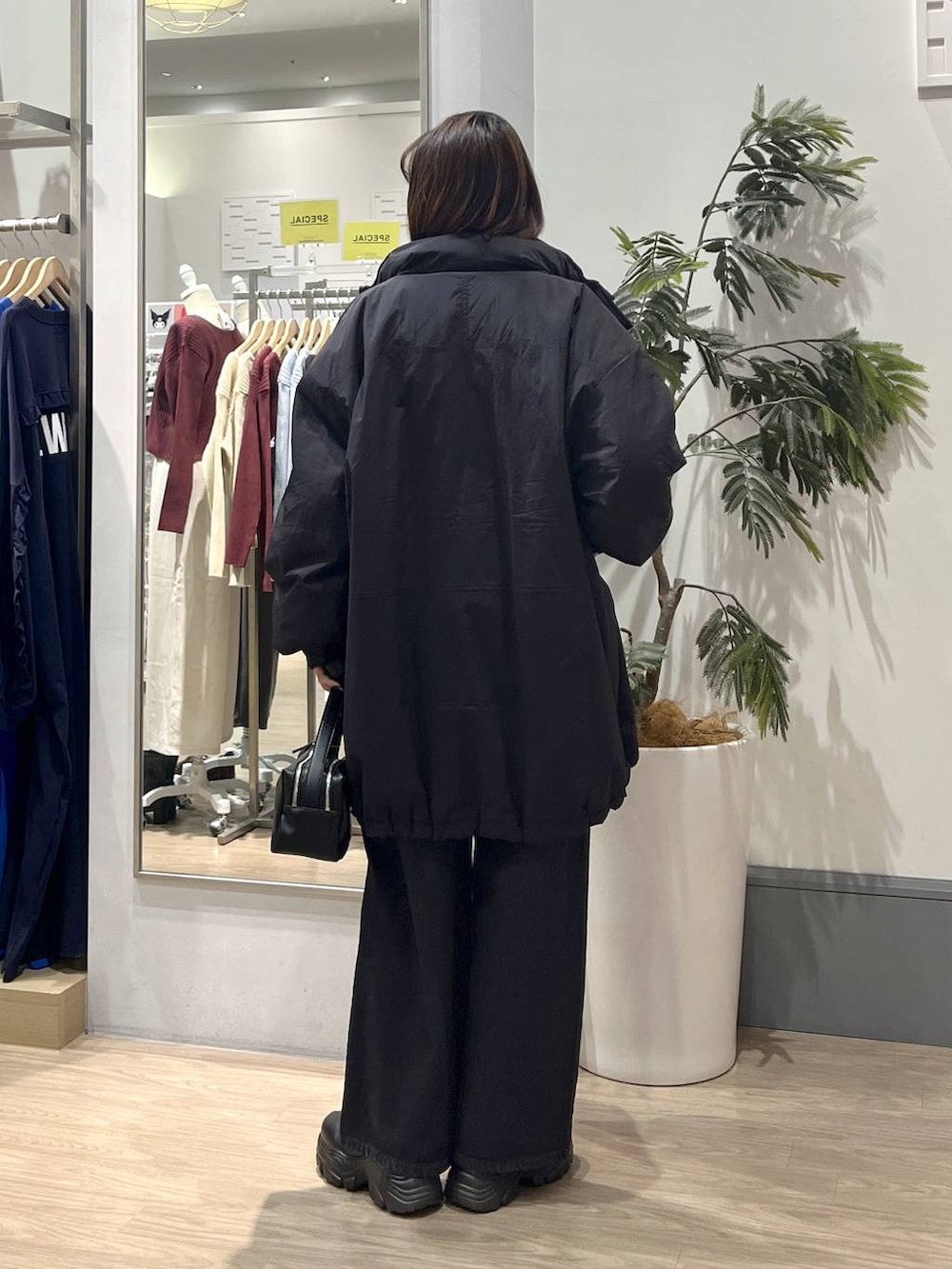 ブラック系のブーツ、ブラック系のショルダーバッグ、ブラック系のデニムパンツを着用したレディースの秋コーディネートの4枚目の写真