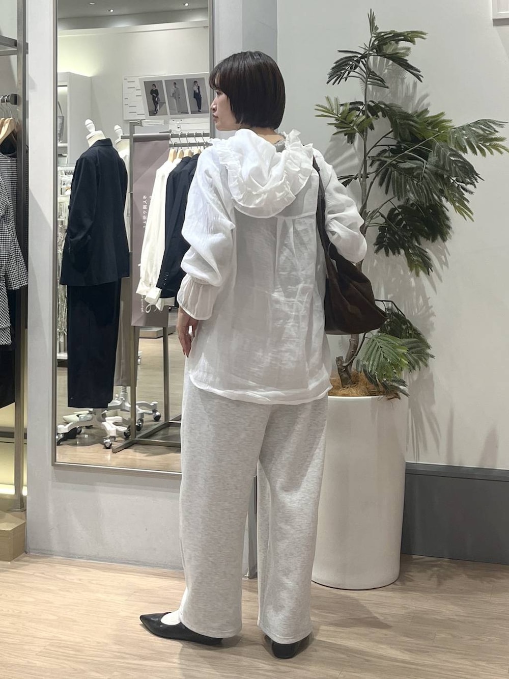 グレー系のスウェットパンツ、ホワイト系のシャツ/ブラウス、ブラック系のパンプスを着用したレディースの冬コーディネートの5枚目の写真
