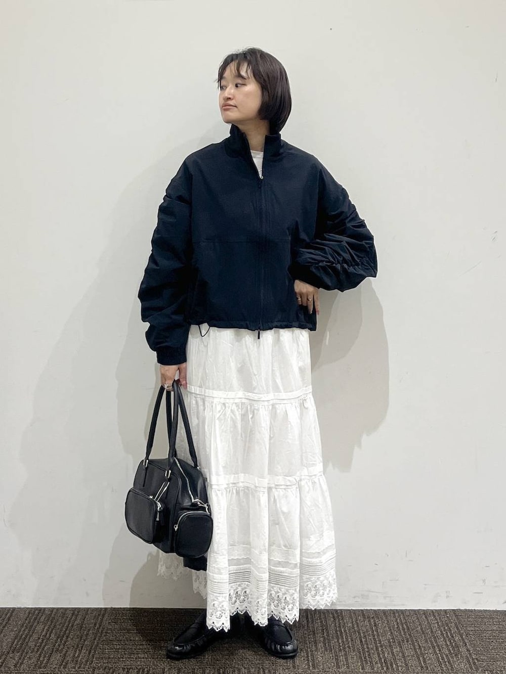 ホワイト系のTシャツ/カットソー、ブラック系のボストンバッグ、ブラック系のローファーを着用したレディースの春コーディネートの2枚目の写真