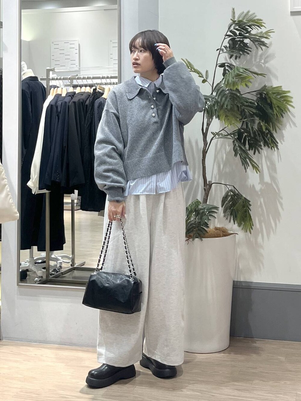 ブラック系のショルダーバッグ、ブラック系のサンダル、ブルー系のシャツ/ブラウスを着用したレディースの冬コーディネートの3枚目の写真