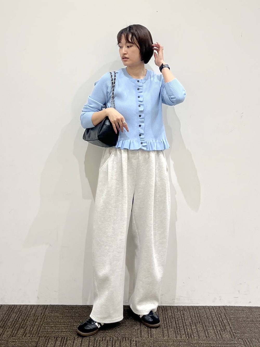 グレー系のスウェットパンツ、ブラック系のショルダーバッグ、ブルー系のTシャツ/カットソーを着用したレディースの冬コーディネートの2枚目の写真