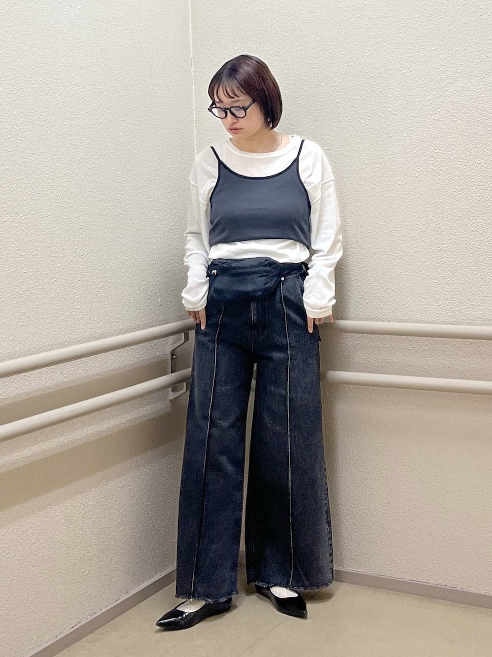 ホワイト系のTシャツ/カットソー、ブラック系のパンプス、ブラック系のデニムパンツを着用したレディースの春コーディネートの2枚目の写真