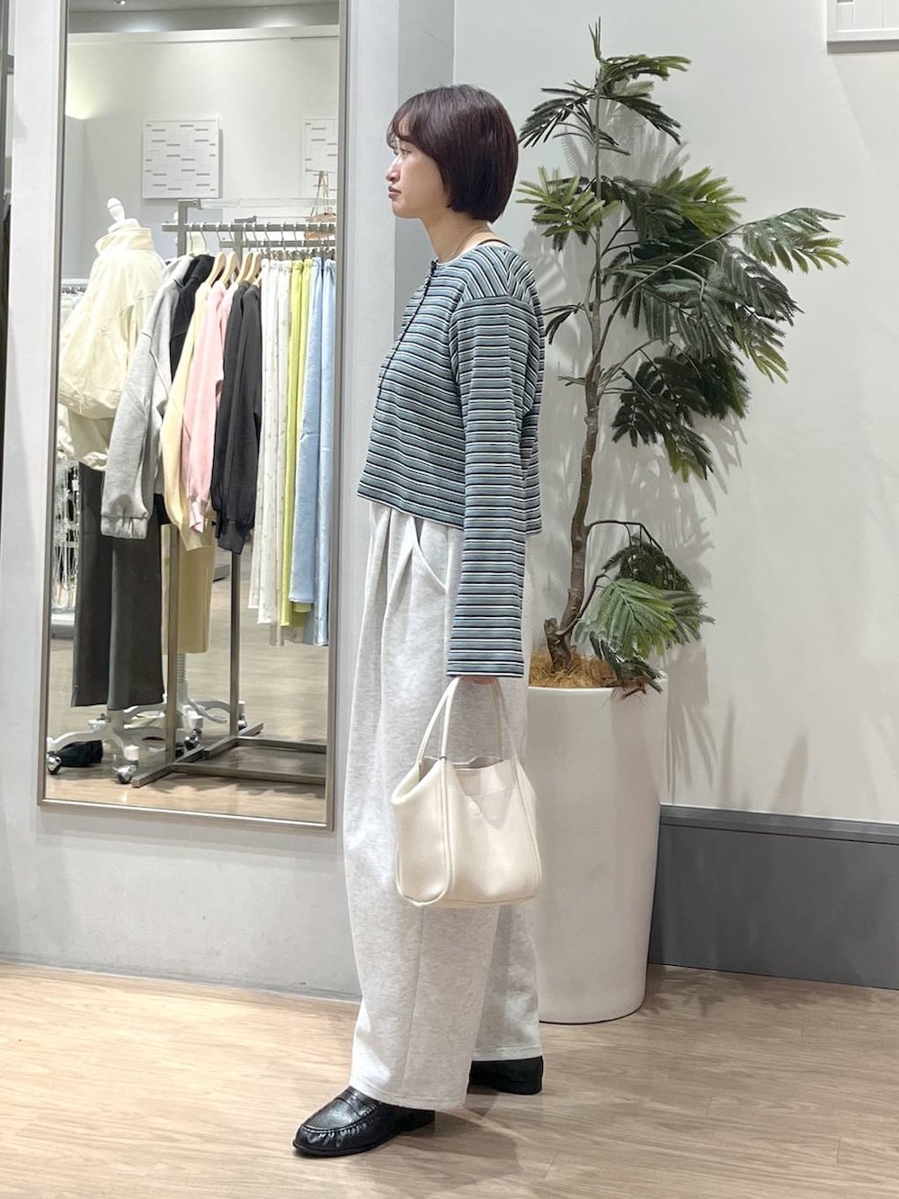 ブラック系のTシャツ/カットソー、グレー系のスウェットパンツ、ホワイト系のショルダーバッグを着用したレディースの春コーディネートの3枚目の写真