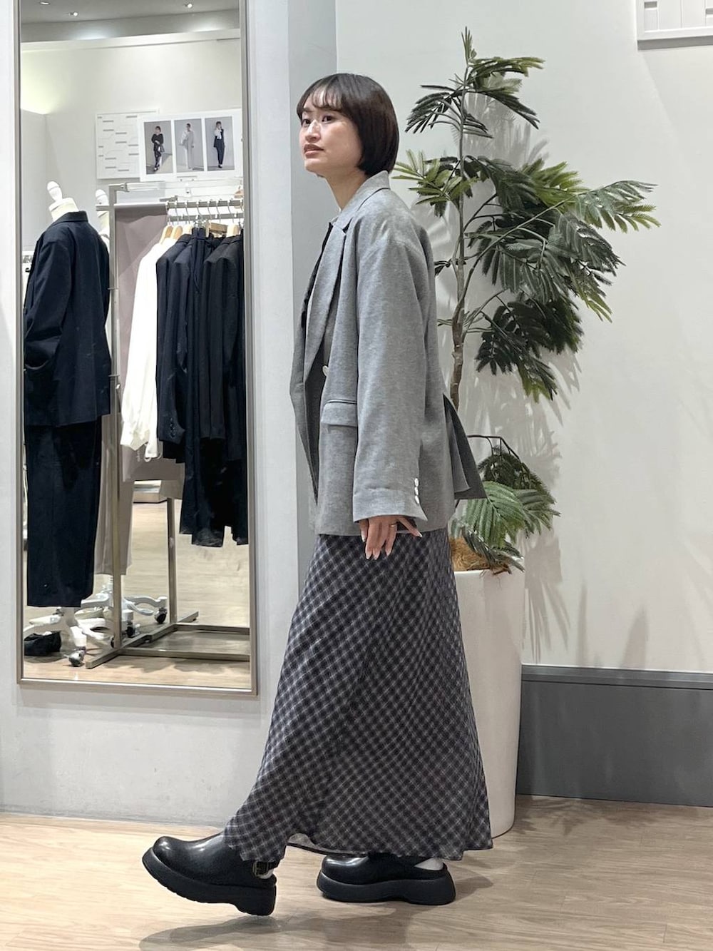 グレー系のテーラードジャケット、ブラック系のショルダーバッグ、ブラック系のサンダルを着用したレディースの春コーディネートの4枚目の写真