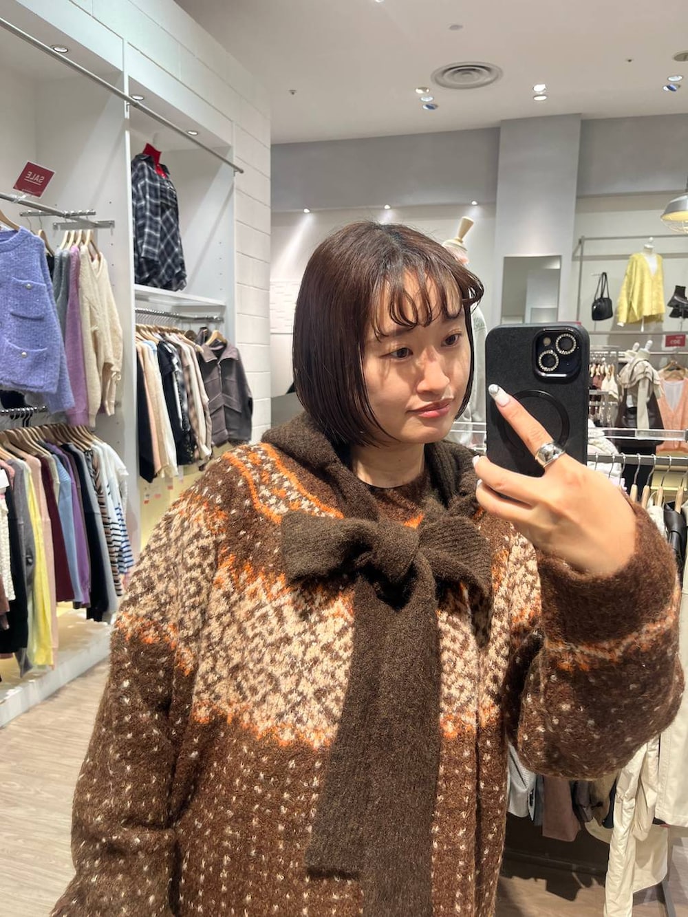 ブラウン系のニット/セーター、ブラウン系のマフラーを着用したレディースの冬コーディネートの3枚目の写真