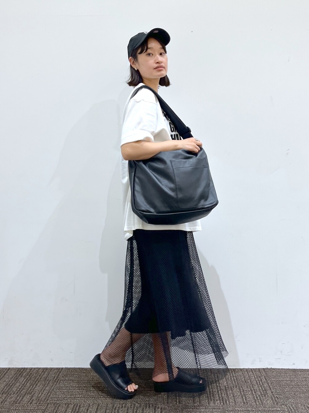 ブラック系のボディバッグ/ウエストポーチ、ホワイト系のTシャツ/カットソー、ブラック系のサンダルを着用したレディースの夏コーディネートの3枚目の写真