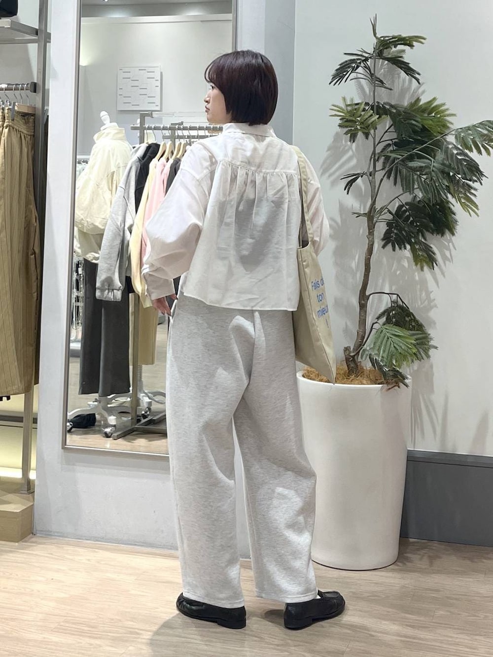 ブラック系のTシャツ/カットソー、グレー系のスウェットパンツ、ベージュ系のトートバッグを着用したレディースの春コーディネートの4枚目の写真