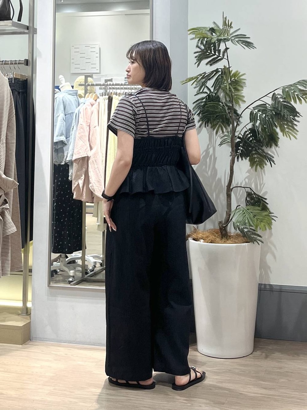 ブラック系のショルダーバッグ、ブラウン系のTシャツ/カットソー、ブラック系のサロペット/オーバーオールを着用したレディースの夏コーディネートの3枚目の写真