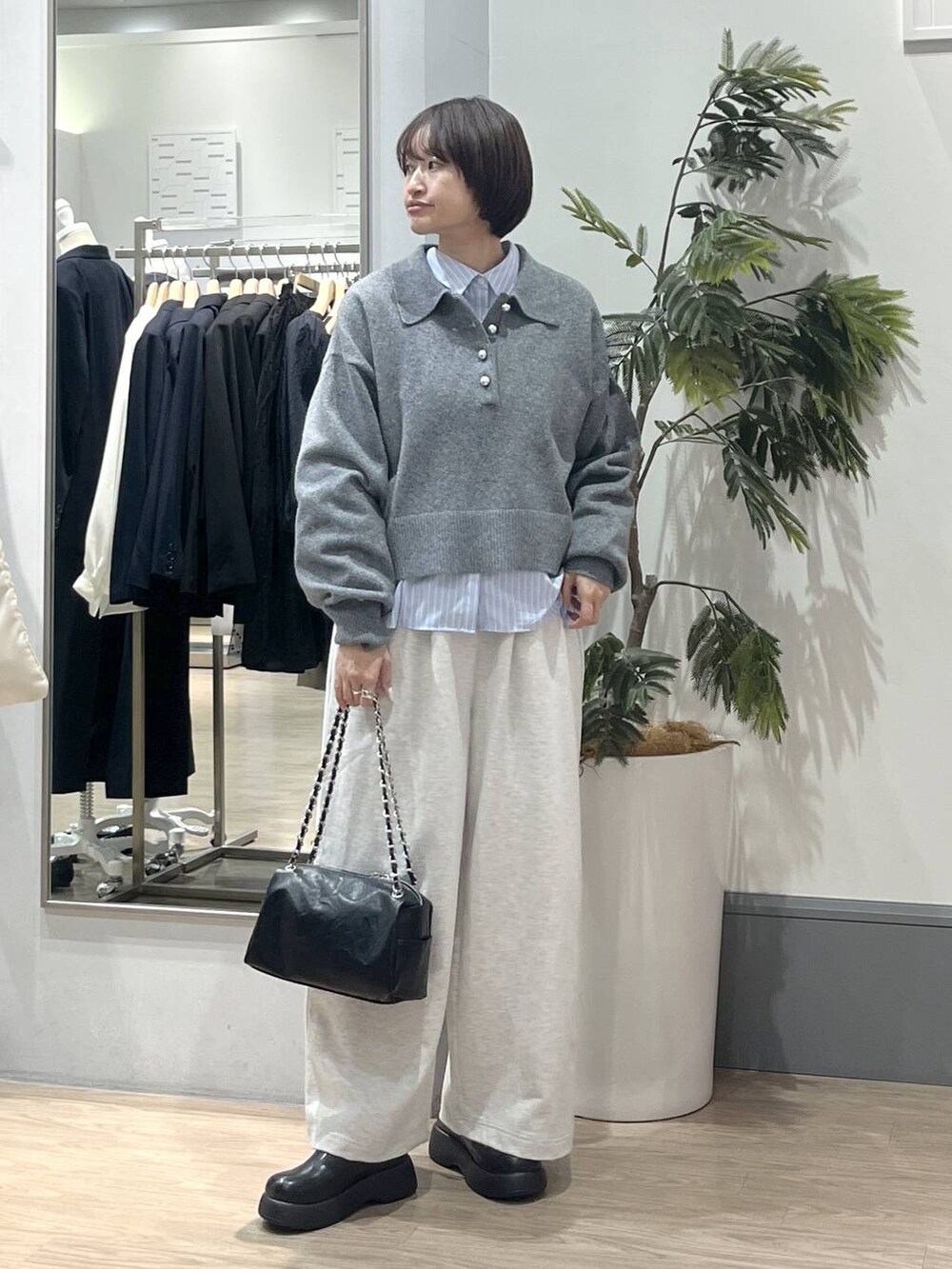 ブラック系のショルダーバッグ、ブラック系のサンダル、ブルー系のシャツ/ブラウスを着用したレディースの冬コーディネートの2枚目の写真