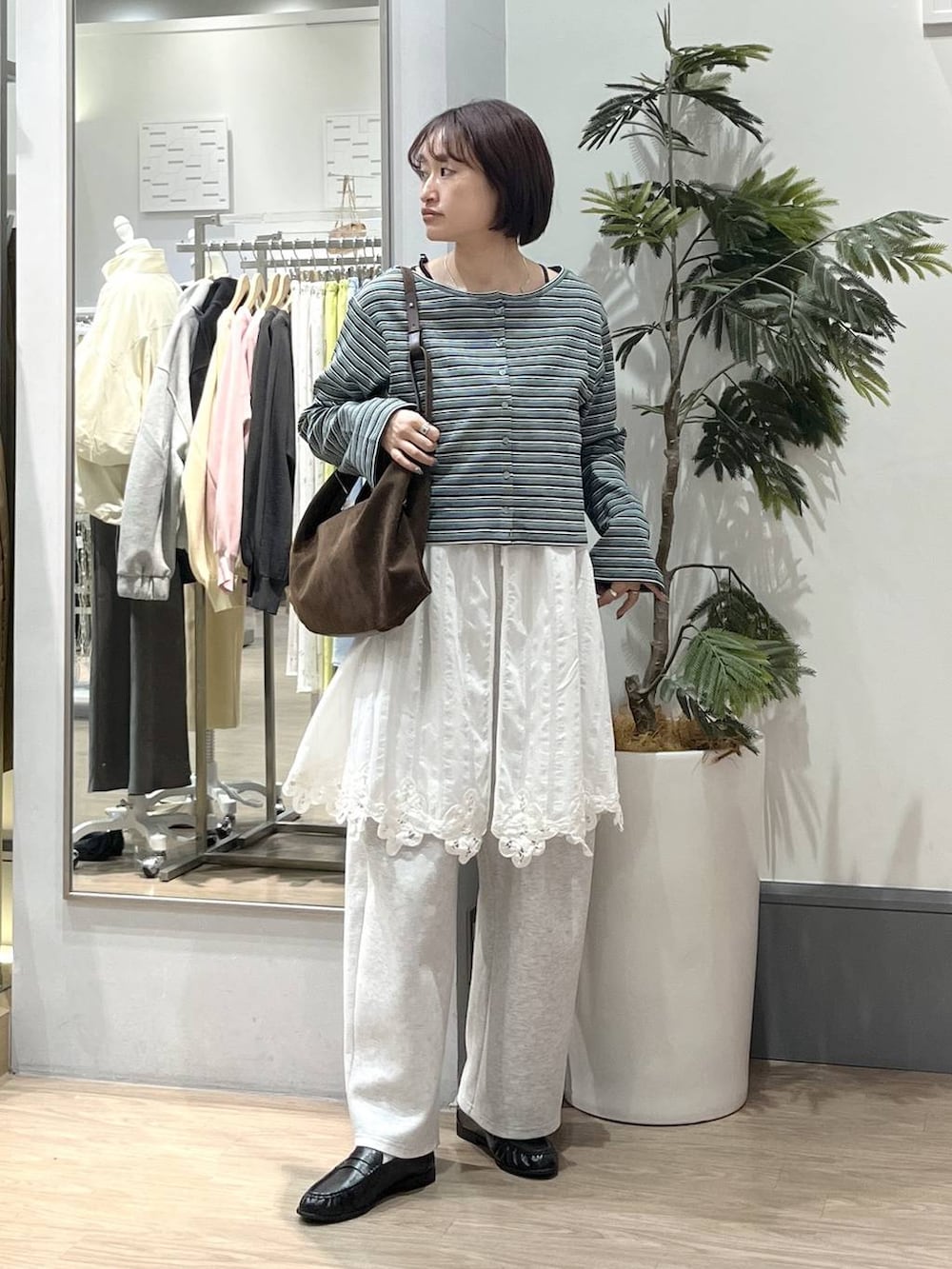 ブラック系のTシャツ/カットソー、グレー系のスウェットパンツ、ブラック系のローファーを着用したレディースの春コーディネートの2枚目の写真