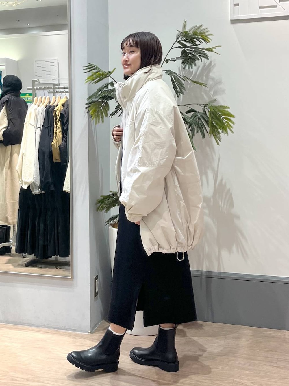 ホワイト系のその他アウター、ブラック系のブーツ、ブラック系のワンピースを着用したレディースの秋コーディネートの3枚目の写真