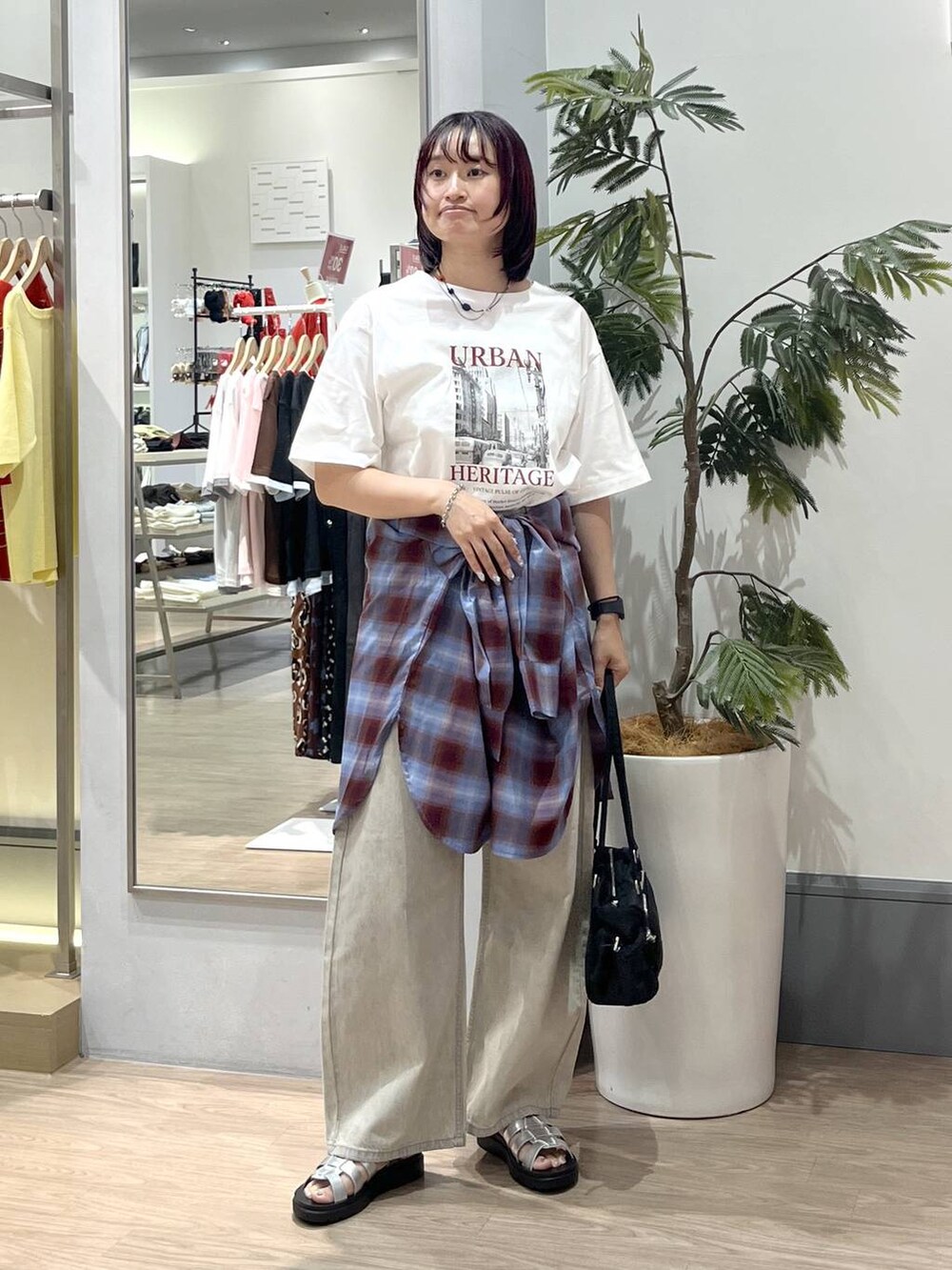 ベージュ系のデニムパンツ、シルバー系のサンダル、ブラック系のボストンバッグを着用したレディースの夏コーディネートの2枚目の写真