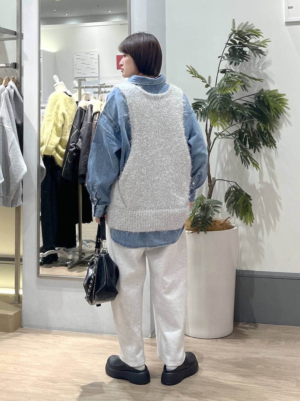 グレー系のスウェットパンツ、ブルー系のシャツ/ブラウス、ブラック系のショルダーバッグを着用したレディースの冬コーディネートの4枚目の写真