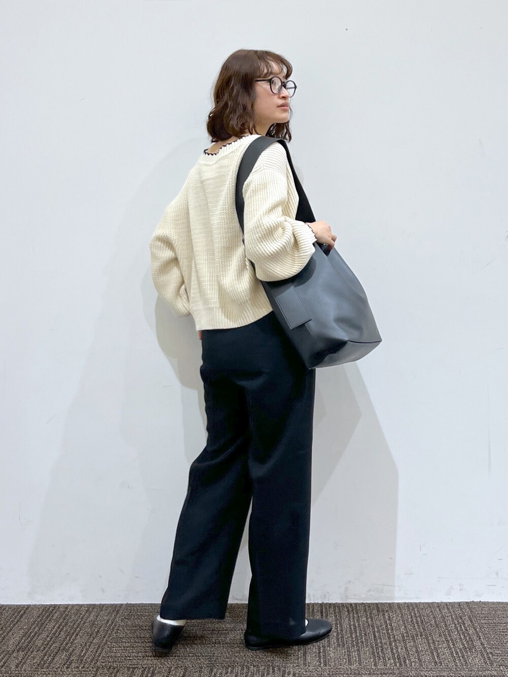 ブラック系のパンツ、ホワイト系のカーディガン/ボレロ、ホワイト系のトップスを着用したレディースの春コーディネートの3枚目の写真