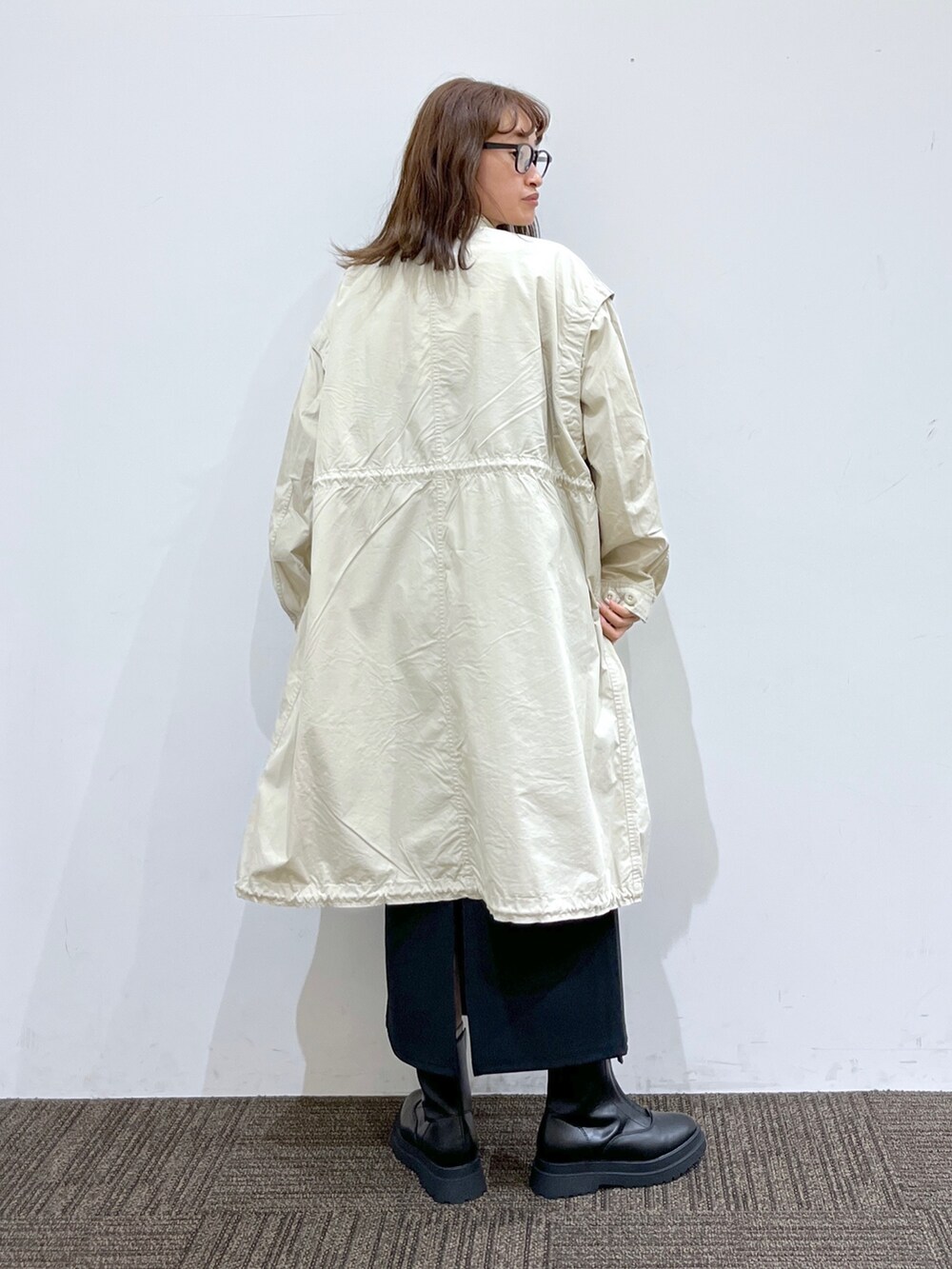 ブラック系のブーツ、ブラック系のバッグ、ブラック系のワンピースを着用したレディースの秋コーディネートの4枚目の写真