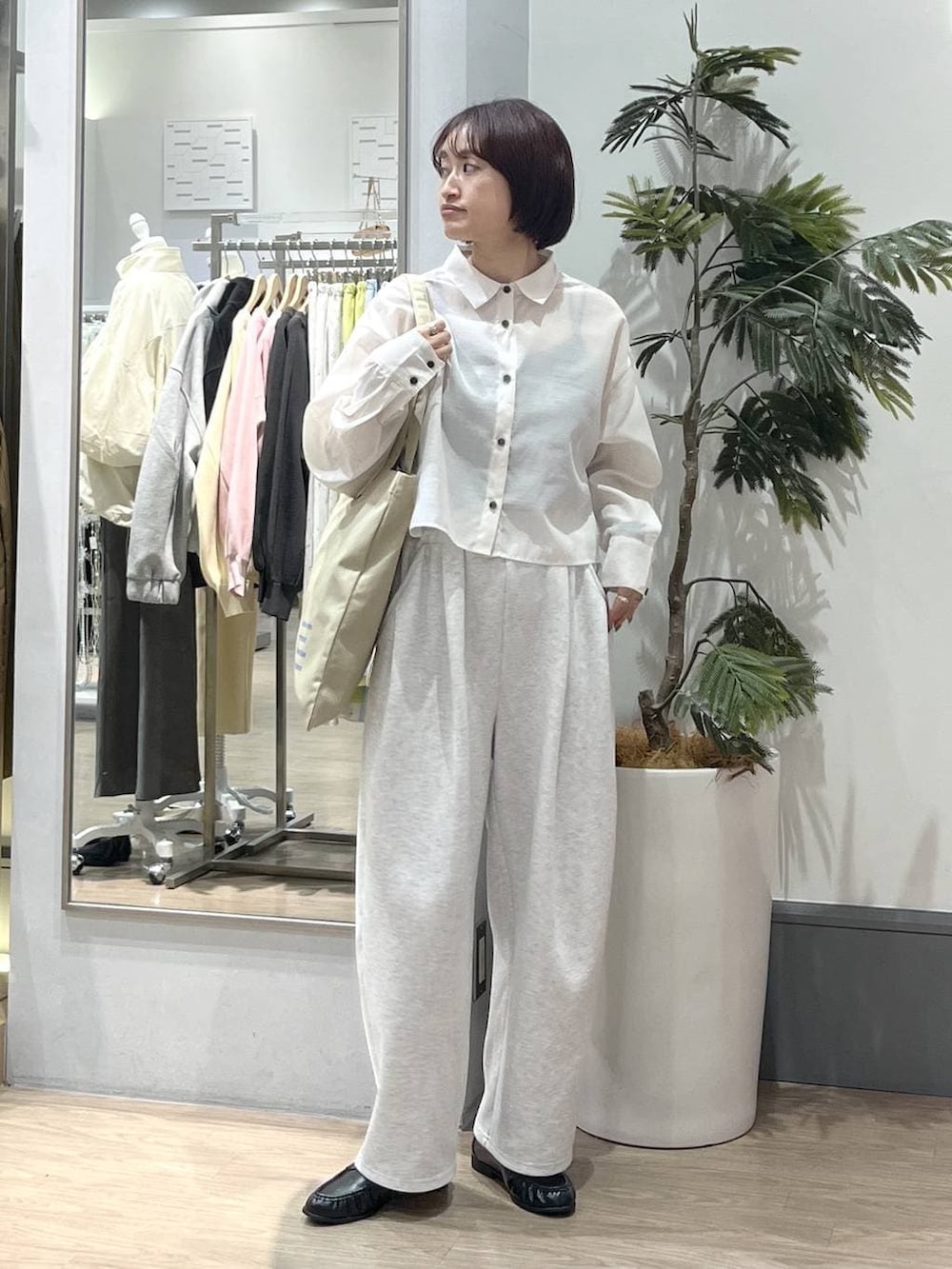 ブラック系のTシャツ/カットソー、グレー系のスウェットパンツ、ベージュ系のトートバッグを着用したレディースの春コーディネートの2枚目の写真