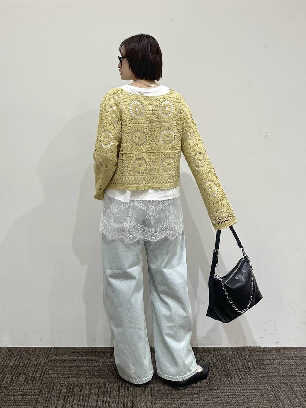 ブラック系のパンプス、ブルー系のデニムパンツ、ブラック系のショルダーバッグを着用したレディースの春コーディネートの4枚目の写真