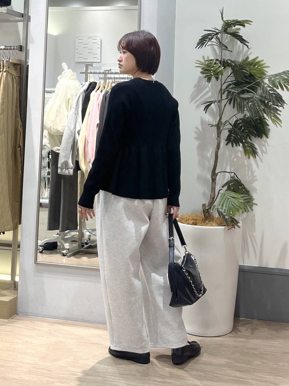 グレー系のスウェットパンツ、ブラック系のショルダーバッグ、ブラック系のローファーを着用したレディースの春コーディネートの5枚目の写真