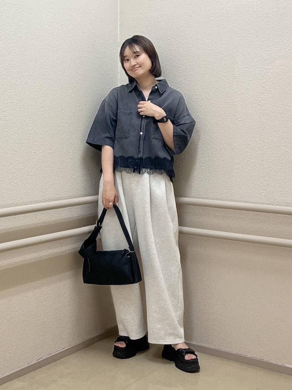 グレー系のスウェットパンツ、ブラック系のショルダーバッグ、ブラック系のシャツ/ブラウスを着用したレディースの夏コーディネートの3枚目の写真