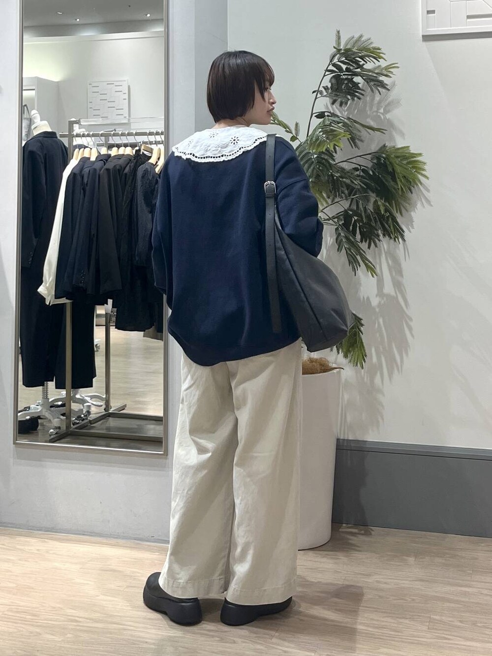 ブラック系のショルダーバッグ、ホワイト系のTシャツ/カットソー、ホワイト系のデニムパンツを着用したレディースの冬コーディネートの4枚目の写真