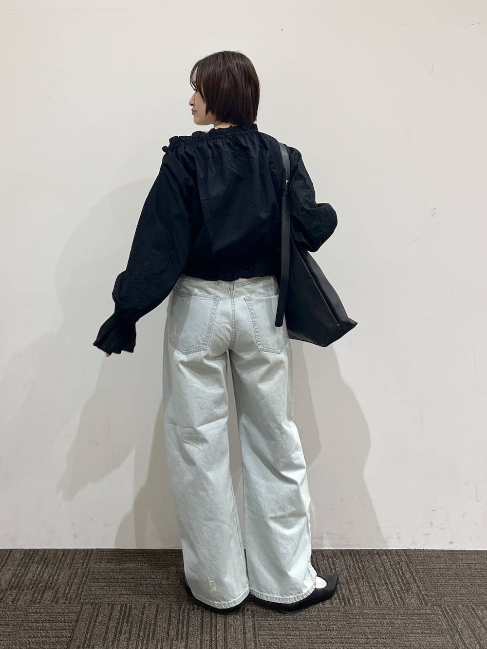 ホワイト系のTシャツ/カットソー、ブラック系のショルダーバッグ、ブラック系のパンプスを着用したレディースの春コーディネートの5枚目の写真