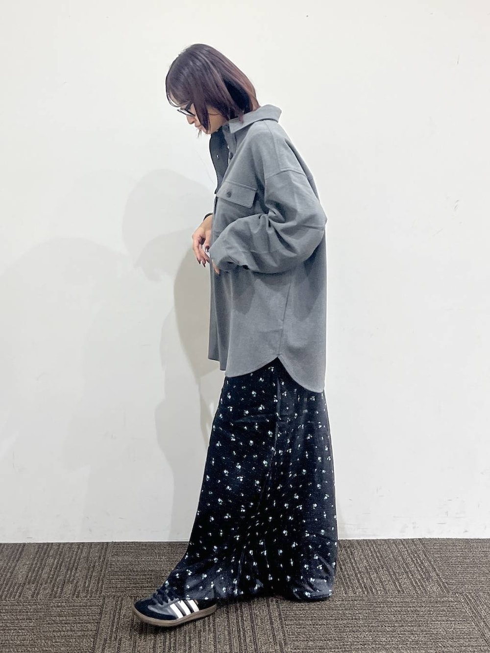 ブラック系のショルダーバッグ、ホワイト系のTシャツ/カットソー、ブラック系のスカートを着用したレディースの秋コーディネートの3枚目の写真