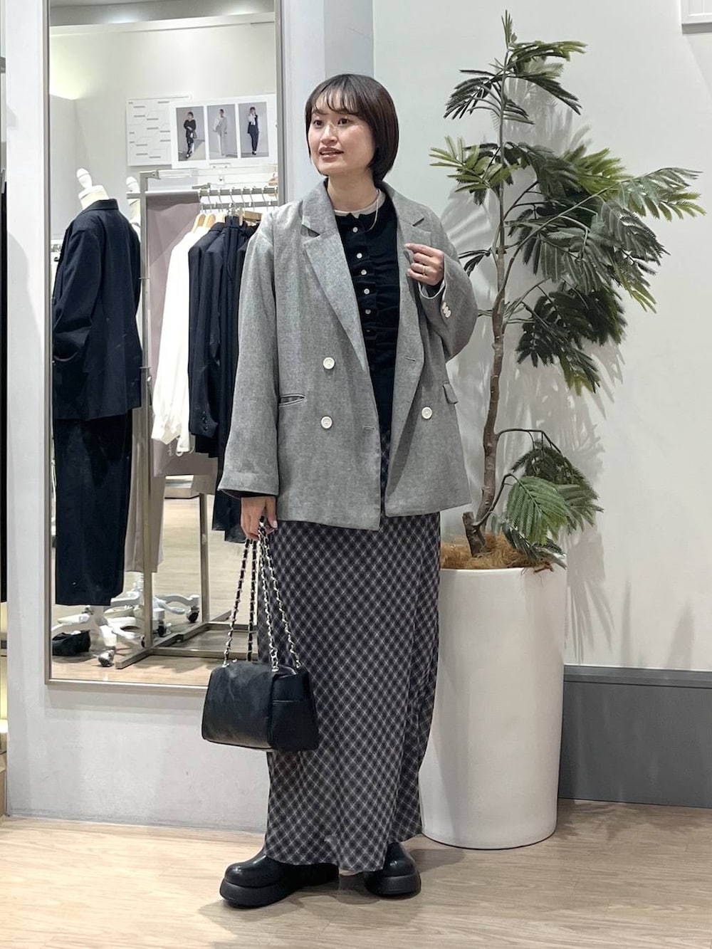 グレー系のテーラードジャケット、ブラック系のショルダーバッグ、ブラック系のサンダルを着用したレディースの春コーディネートの3枚目の写真