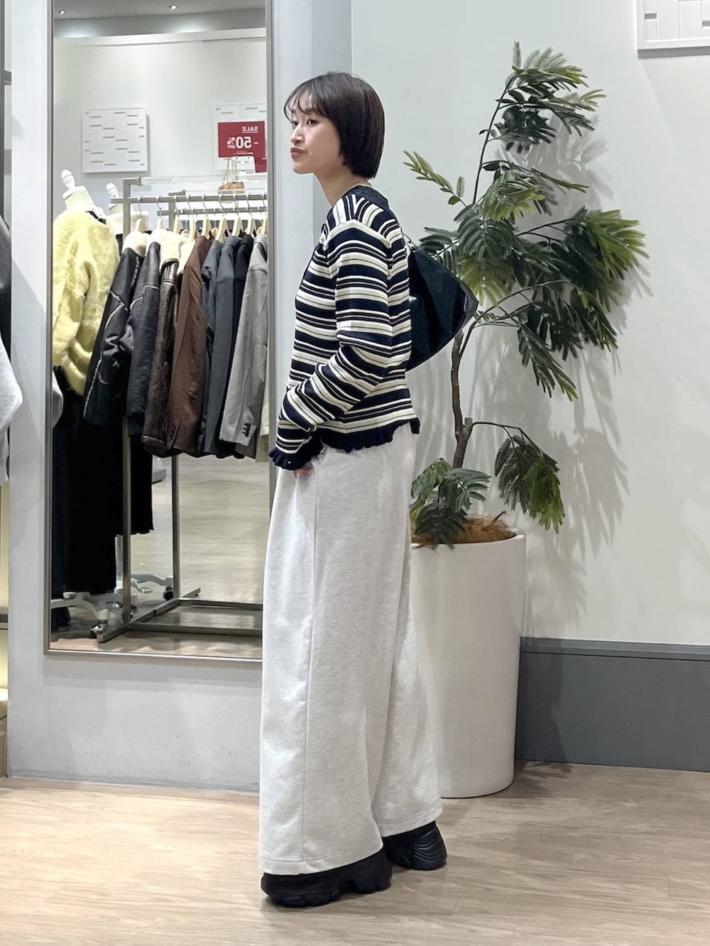 ブラック系のショルダーバッグ、ブラック系のローファー、グレー系のスウェットパンツを着用したレディースの冬コーディネートの3枚目の写真