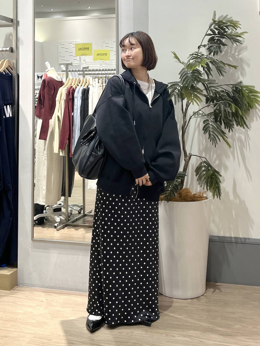 ブラック系のスカート、ブラック系のパーカー、ホワイト系のTシャツ/カットソーを着用したレディースの秋コーディネートの2枚目の写真