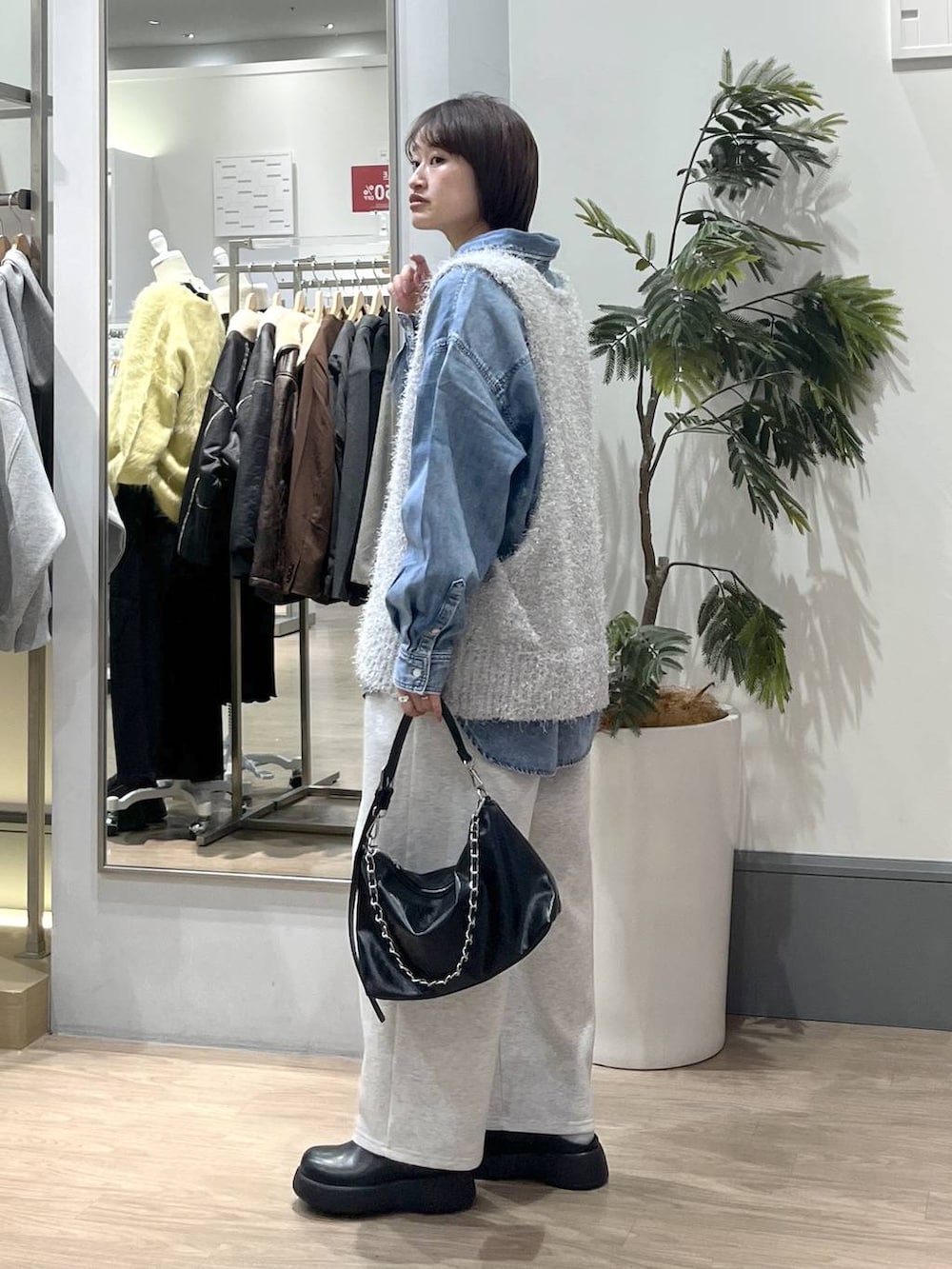 グレー系のスウェットパンツ、ブルー系のシャツ/ブラウス、ブラック系のショルダーバッグを着用したレディースの冬コーディネートの3枚目の写真