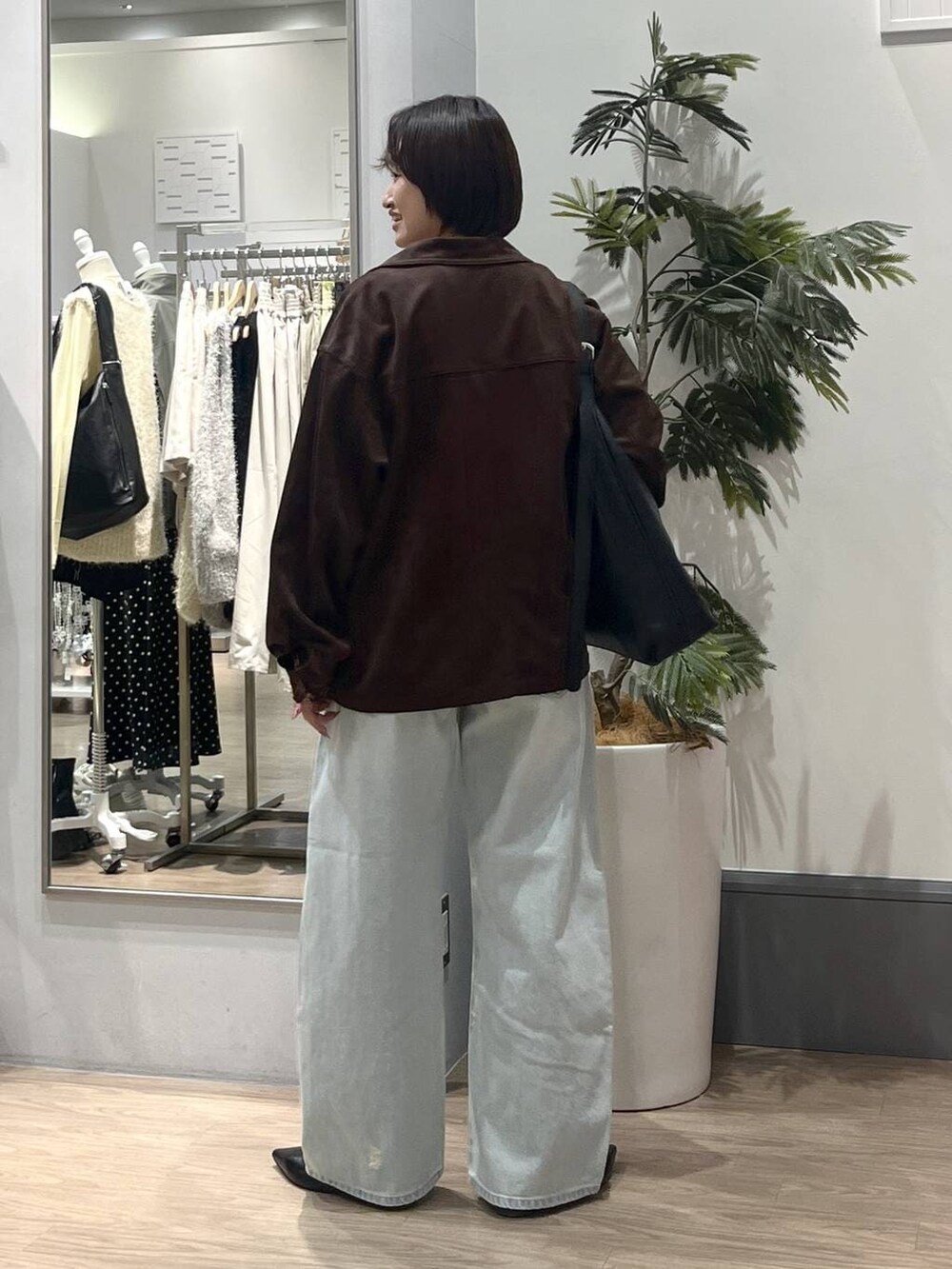 ブラック系のショルダーバッグ、ブラック系のパンプス、ホワイト系のTシャツ/カットソーを着用したレディースの冬コーディネートの4枚目の写真